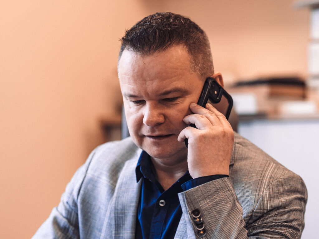 Mirosław Dybowski z GAMP rozmawia przez telefon w biurze w Zielonej Górze