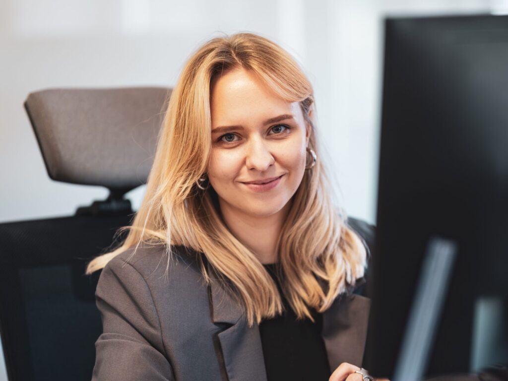 Dominika Gawara z GAMP przy biurku w biurze.